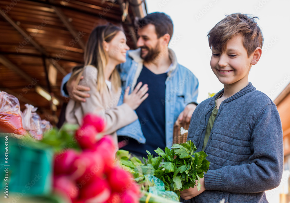 Family Buying Fresh Vegetables At Farmers Market Stall Family Buying Fresh Vegetables At Farmers Market Stall