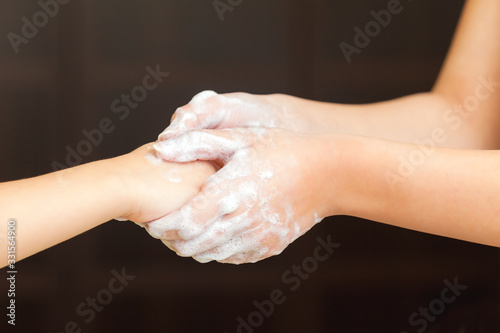 Adult shows to kid how to wash hands