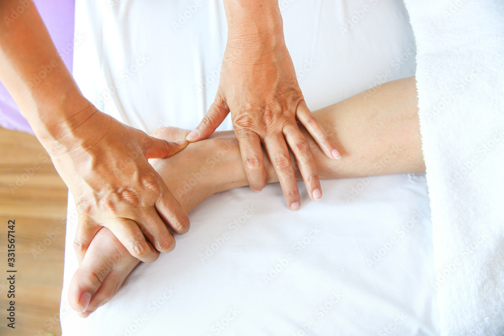 Fototapeta premium Masseuse use two hand to foot massage with young female