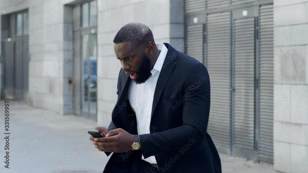 Businessman looking on smartphone at street. Manager using cellphone outdoors Businessman looking on smartphone at street. Manager using cellphone outdoors