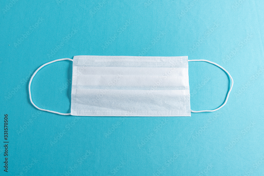 Surgical mask over minimalist blue background Surgical mask over minimalist blue background