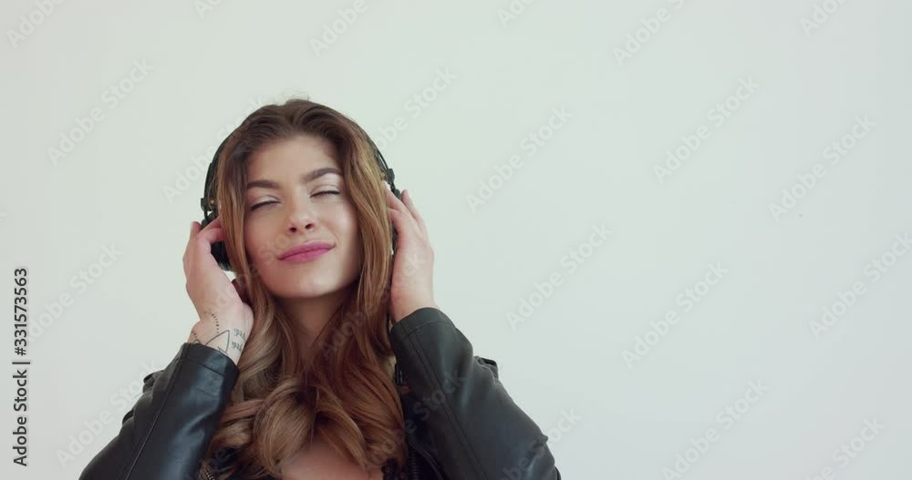 Attractive girl takes off headphones, flirts and smiles into a camera Attractive girl takes off headphones, flirts and smiles into a camera