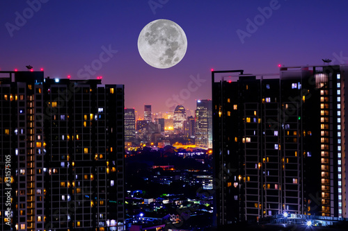 Thailand. Night skyline panorama of Bangkok with full moon from Lebua Sky Bar. Wide angle photo of Bangkok skyscrapers and city lights. photo