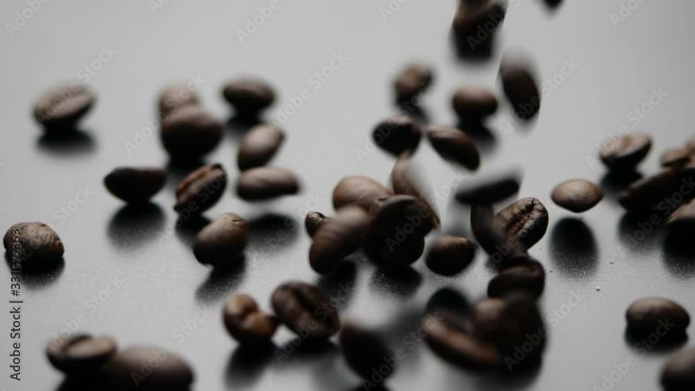 Coffee beans falling on dark background in slow motion. Close-up of seeds of coffee. Coffee beans falling on dark background in slow motion. Close-up of seeds of coffee.