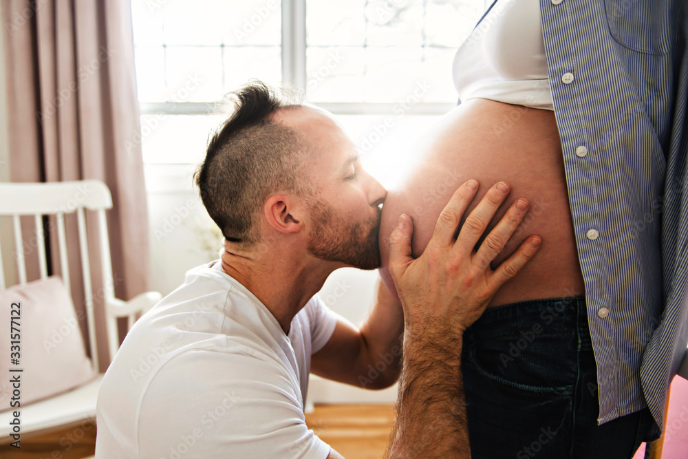 husband on the baby room at home with pregnant woman belly - obrazy, fototapety, plakaty 