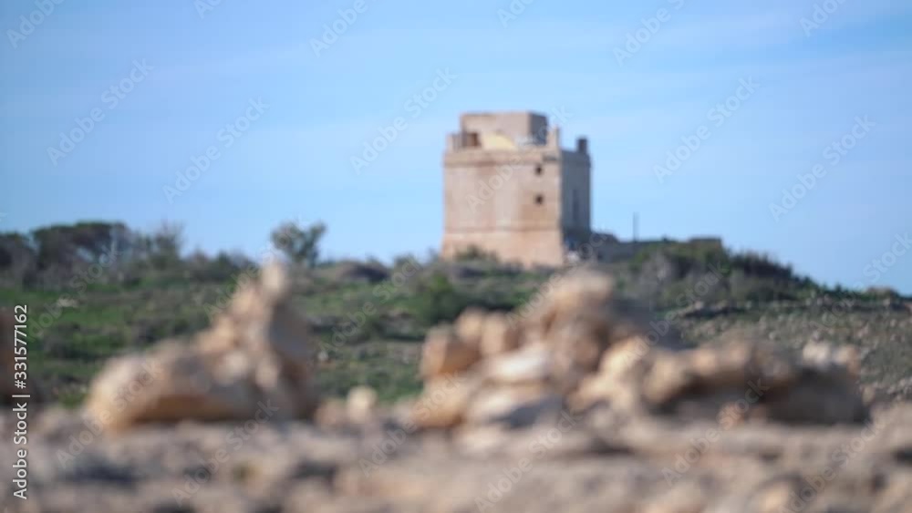 Focus changing from a stack of rock to a medieval defense tower background Focus changing from a stack of rock to a medieval defense tower background