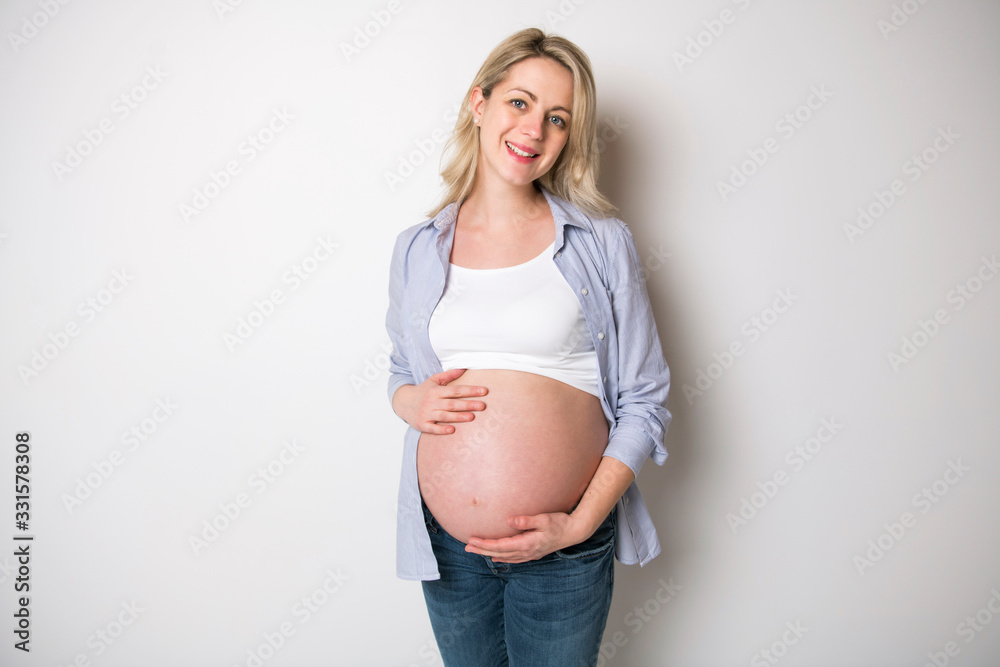 pregnant woman caressing her belly over white background pregnant woman caressing her belly over white background