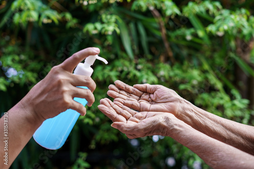Women's hand offer disinfectant alcohol gel to elderly women To prevent and stop pathogens coronavirus