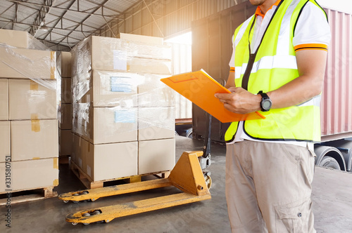 Worker courier holding clipboard inspecting checklist load shipment goods into a truck, Freight industry warehouse logistics transport, forklift pallet jack and stack package boxes.