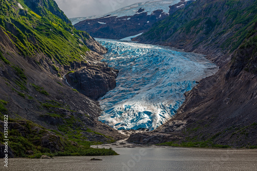 The Bear Glacier and Strohne Lake in the United states of America illuminated by the first sun rays, between Hyder in Alaska and Stewart in British Columbia, Canada, Kenai fjords national park.