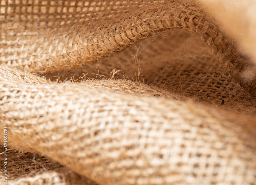 Close up view on crumpled burlap fabric. Brown baline, abstract background. Texture of brown sackcloth. Selective soft focus. Blurred background Close up view on crumpled burlap fabric. Brown baline, abstract background. Texture of brown sackcloth. Selective soft focus. Blurred background