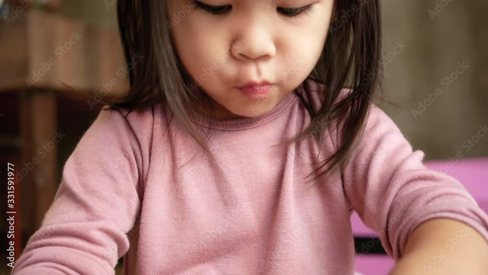 Asian little child girl having fun to eat noodles in plastic cup at home. Junk food concept. Asian little child girl having fun to eat noodles in plastic cup at home. Junk food concept.