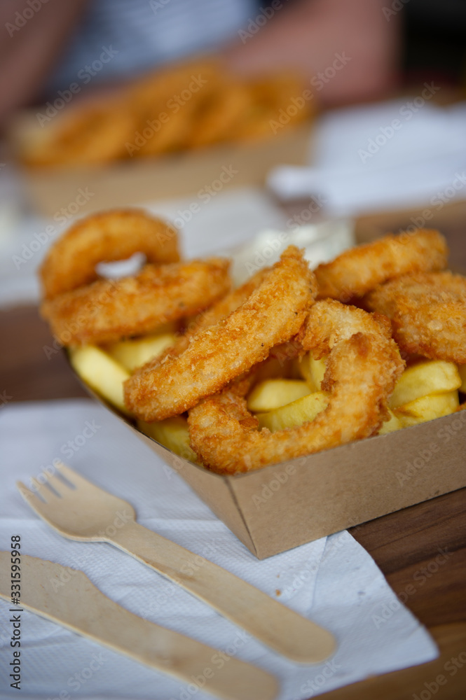 takeaway calamari and chips served in a cardboard plate