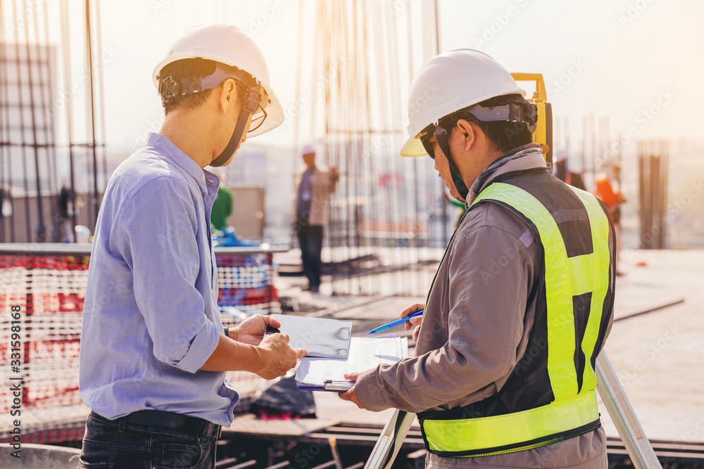 Engineer and surveyor worker working with theodolite transit equipment at outdoors construction site. Engineer and surveyor worker working with theodolite transit equipment at outdoors construction site.