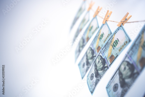 Washing money concept. 100 Dollar bills hanging on a washing line. Symbol of money laundering. Copy space soft focus. photo
