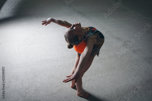 Fototapeta Naklejka Na Ścianę i Meble -  A girl in a tracksuit doing exercises with ball on a white background. Healthy lifestyle concept, sports uniforms, world Cup, gym, specialized clothing, uniforms