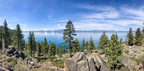 Beautiful Lake Tahoe with pine trees and rocks along the bank