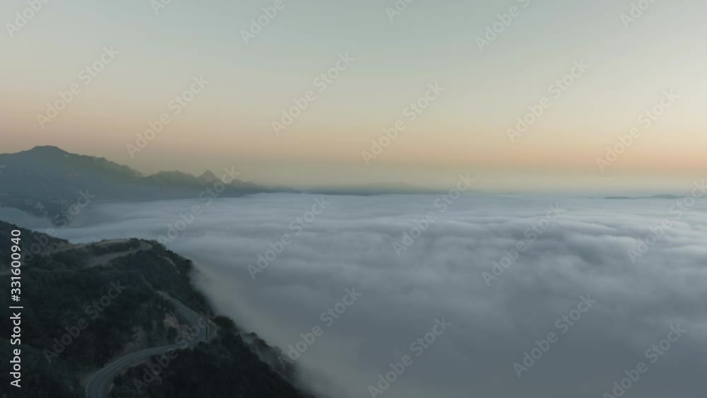 Aerial view flying over a lush green mountain with a bend of the road under the cloud (Malibu Canyon, Calabasas, California, USA) Aerial view flying over a lush green mountain with a bend of the road under the cloud (Malibu Canyon, Calabasas, California, USA)
