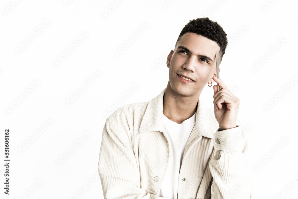 Thoughtful man holding pen and looking up. Portrait of pensive handsome young man holding pen near forehead and looking away. Facial expression concept Thoughtful man holding pen and looking up. Portrait of pensive handsome young man holding pen near forehead and looking away. Facial expression concept