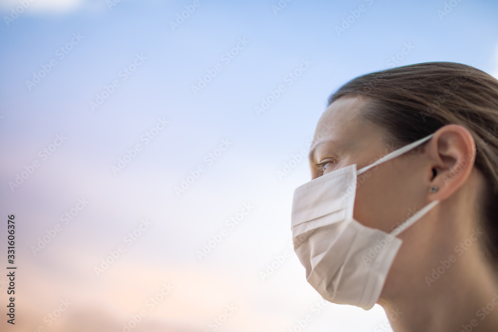 Woman wearing mask on blue sky background. Outbreak of the corona virus in China, illness. Epidemic Woman wearing mask on blue sky background. Outbreak of the corona virus in China, illness. Epidemic