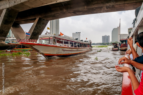 Photography Boat traffic on the Chao Phraya River in central Bangkok, Thailand, near the Tak