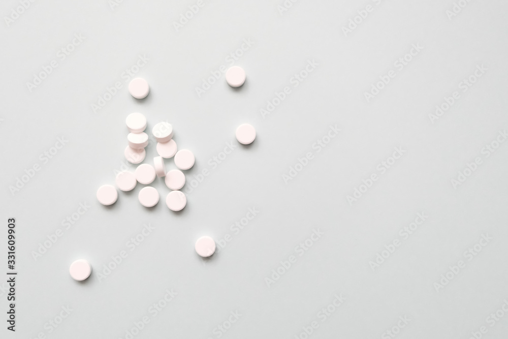 many white pills on a light background