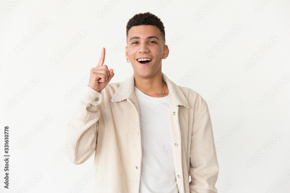 Content man with open mouth. Cheerful young man pointing up with finger and having idea, looking at camera. Idea concept Content man with open mouth. Cheerful young man pointing up with finger and having idea, looking at camera. Idea concept