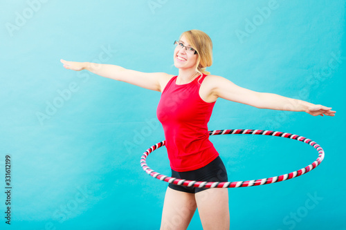 Fit woman with hula hoop doing exercise photo