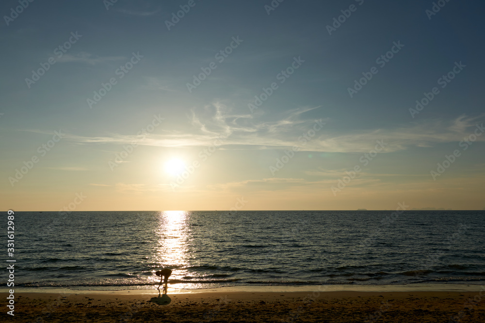Woman collects mussels at Long Beach Thailand