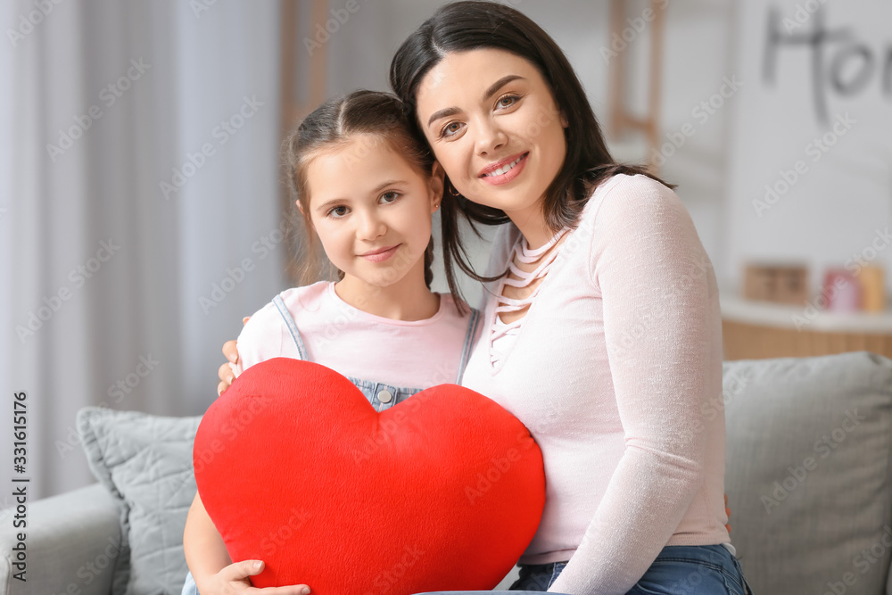 Little girl and her mother with red plush heart at home Little girl and her mother with red plush heart at home