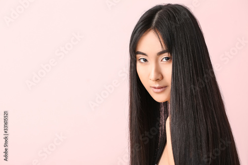 Картината върху платно Young Asian woman with beautiful long hair on color background