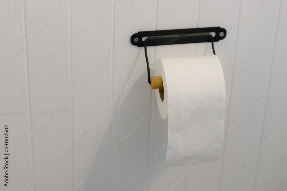 soft toilet paper roll on white wall in bathroom with copy space soft toilet paper roll on white wall in bathroom with copy space