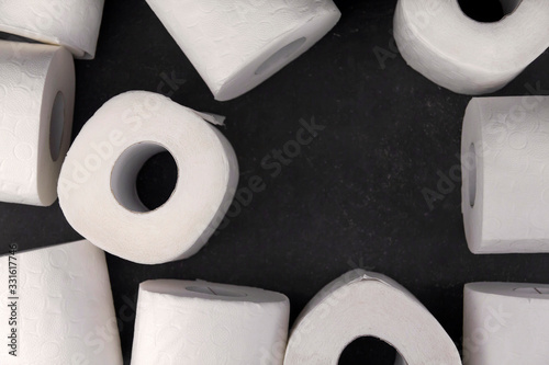 .White toilet paper rolls on a dark gray background copy space. Shortage of toilet paper. photo