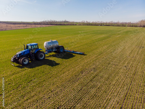 The introduction liquid mineral fertilizers into soil with tractor winter wheat