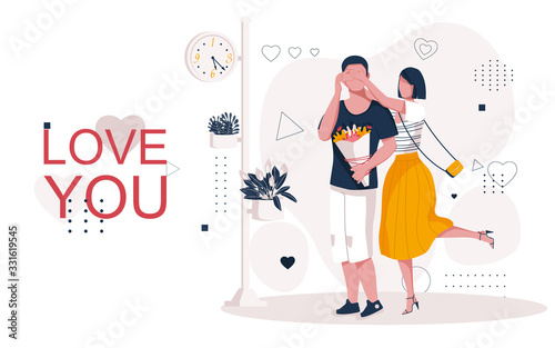 Love date of a young couple under the clock. A man with a bouquet of flowers waiting for his girlfriend. The girl comes up behind the man and covers his eyes with her hands so he can guess who it is. 