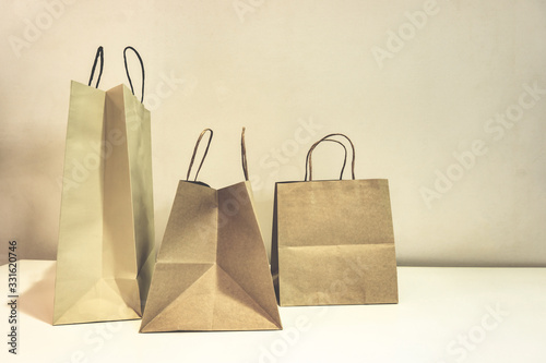 The brown color shopping paper bags on the table and the light brown wallpaper