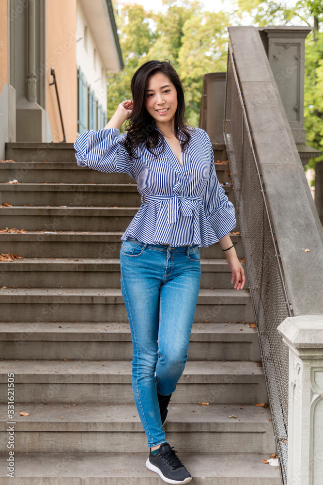 Young Asian Girl walking down stairs in Europe city. Europe city woman traveller lifestyle. Travel Europe summer holiday girl enjoying her holiday. Vacation and Holidays in Zurich and Europe concept.