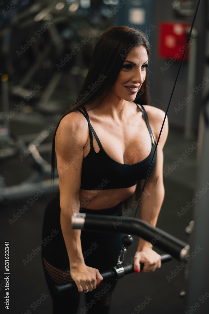 Fototapeta premium Fitness woman on training. Young woman in the gym. 