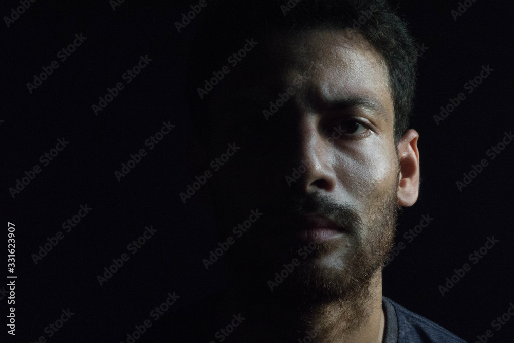 Fototapeta premium Handsome face man on black background with copy space