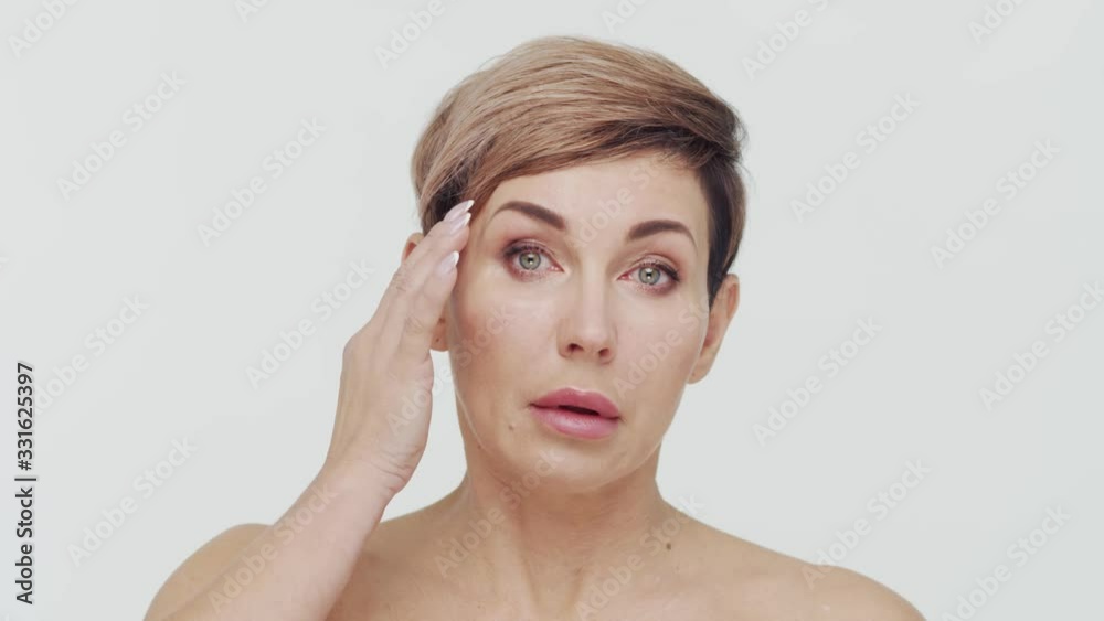 Close-up of middle aged mature woman over white bacjground. Portrait of mature lady. Plastic surgery, beauty injections and cosmetology. Close-up of middle aged mature woman over white bacjground. Portrait of mature lady. Plastic surgery, beauty injections and cosmetology.