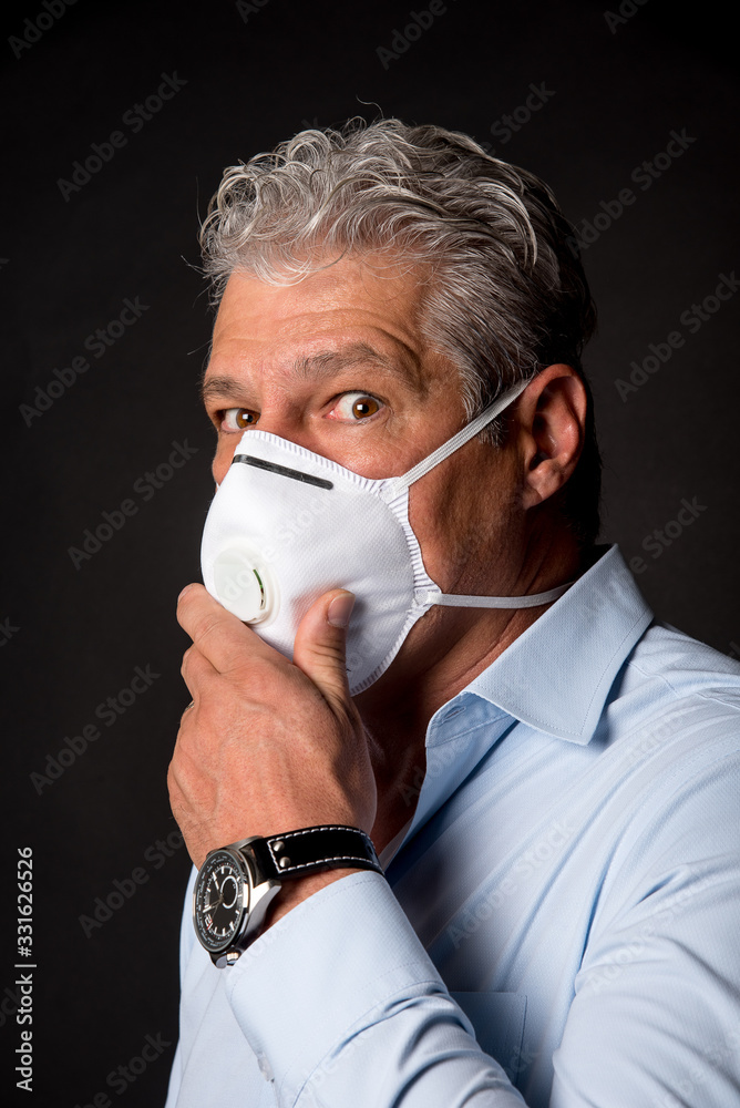 scary looking man wearing PPE,  fpp2 mask and holding it