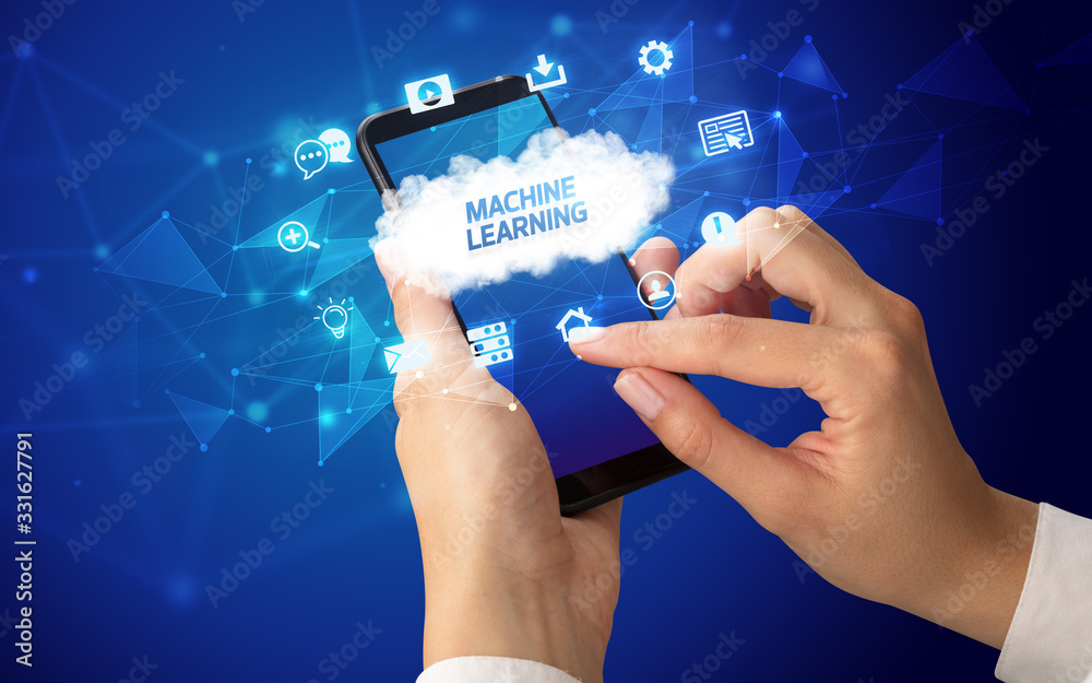 Female hand holding smartphone with MACHINE LEARNING inscription, cloud technology concept Female hand holding smartphone with MACHINE LEARNING inscription, cloud technology concept