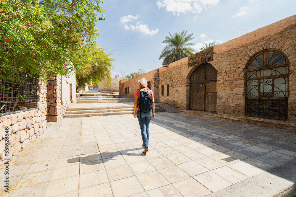 Tourist with backpack walking on street in Aqaba, Jordan.