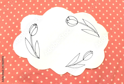 Photo of white paper in the shape of cloud on pink polka dot fabric. Background for text, greetings, invitations, holiday, Easter. Color abstract mockup template with flower tulip