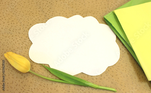 Photo of white paper in the shape of cloud on beige fabric. Background for text, greetings, invitations, holiday, Easter. Color abstract mockup template with flower tulip