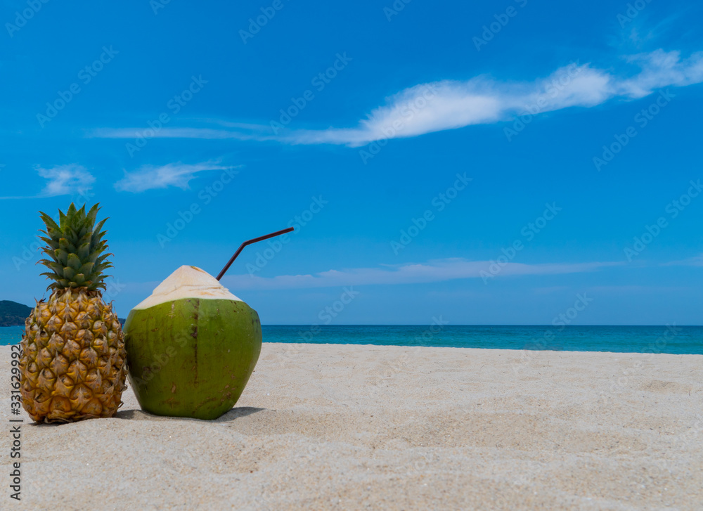 Refreshing pineapple and coconut on a beautiful sandy exotic beach Refreshing pineapple and coconut on a beautiful sandy exotic beach