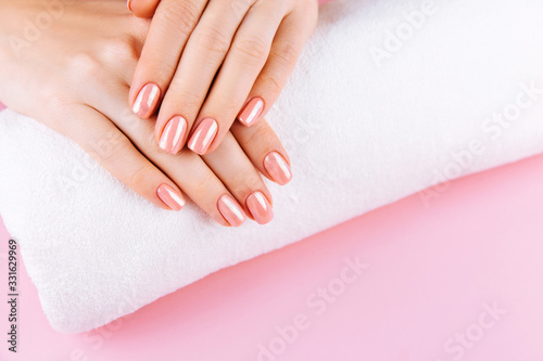 Beautiful Woman Hands with fresh eustoma. Spa and Manicure concept. Female hands with pink manicure. Soft skin  skincare concept. Beauty nails. Over beige background