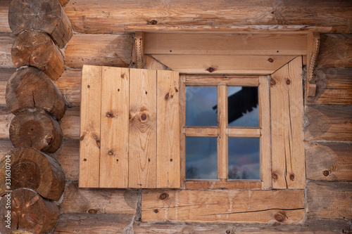 Traditional old houses made of wooden planks. Fragment of an ancient wall with a window