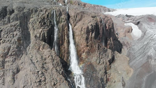 Aerial, drone shot around a waterfall, at the Drangajokull glacier, on a sunny day, in Westfjords, Iceland photo