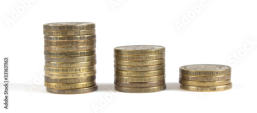Photo Three columns of metal coins were one in a descending order on a white background